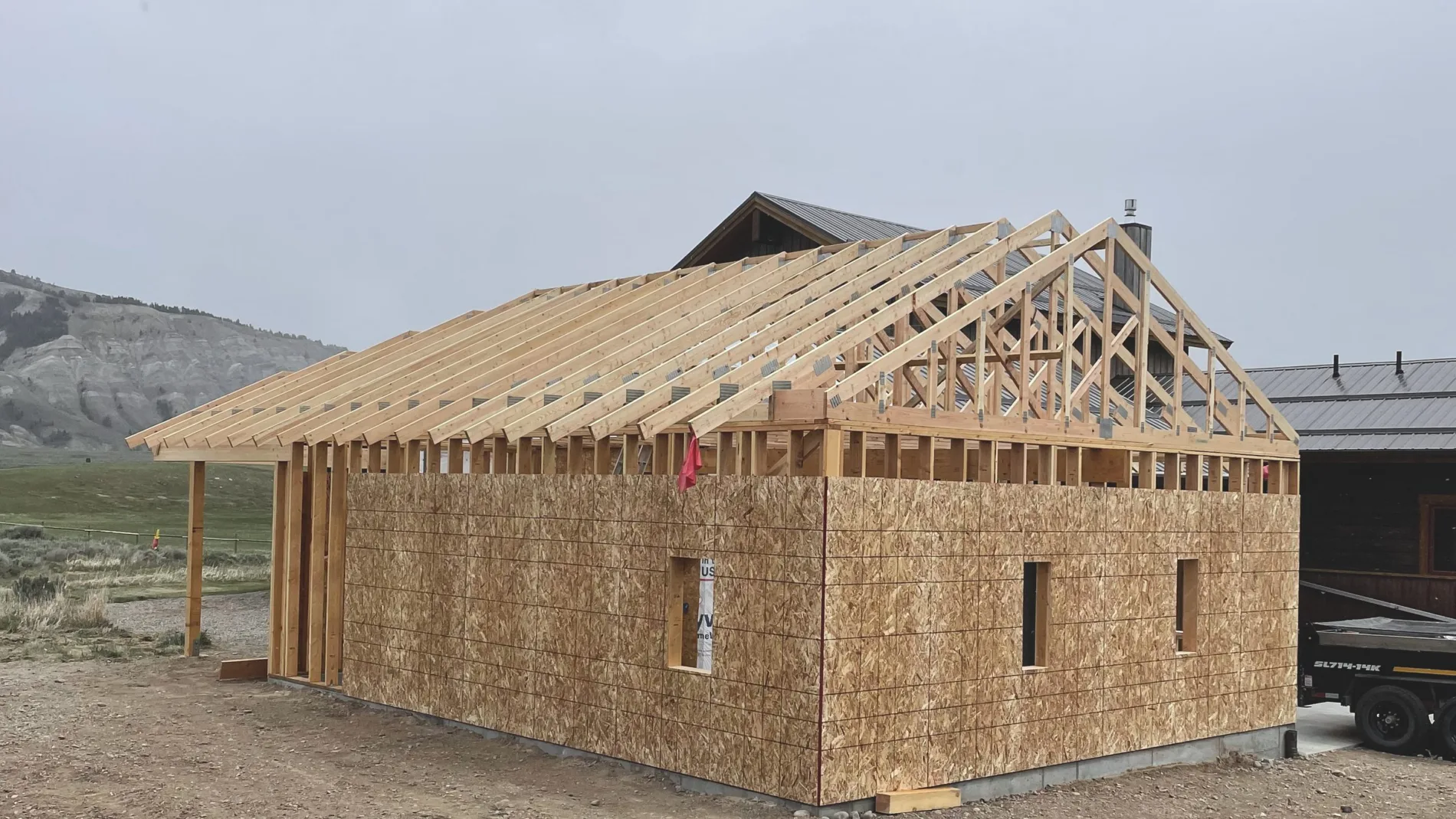 Roof sheathing going on over set trusses, working from the eave up