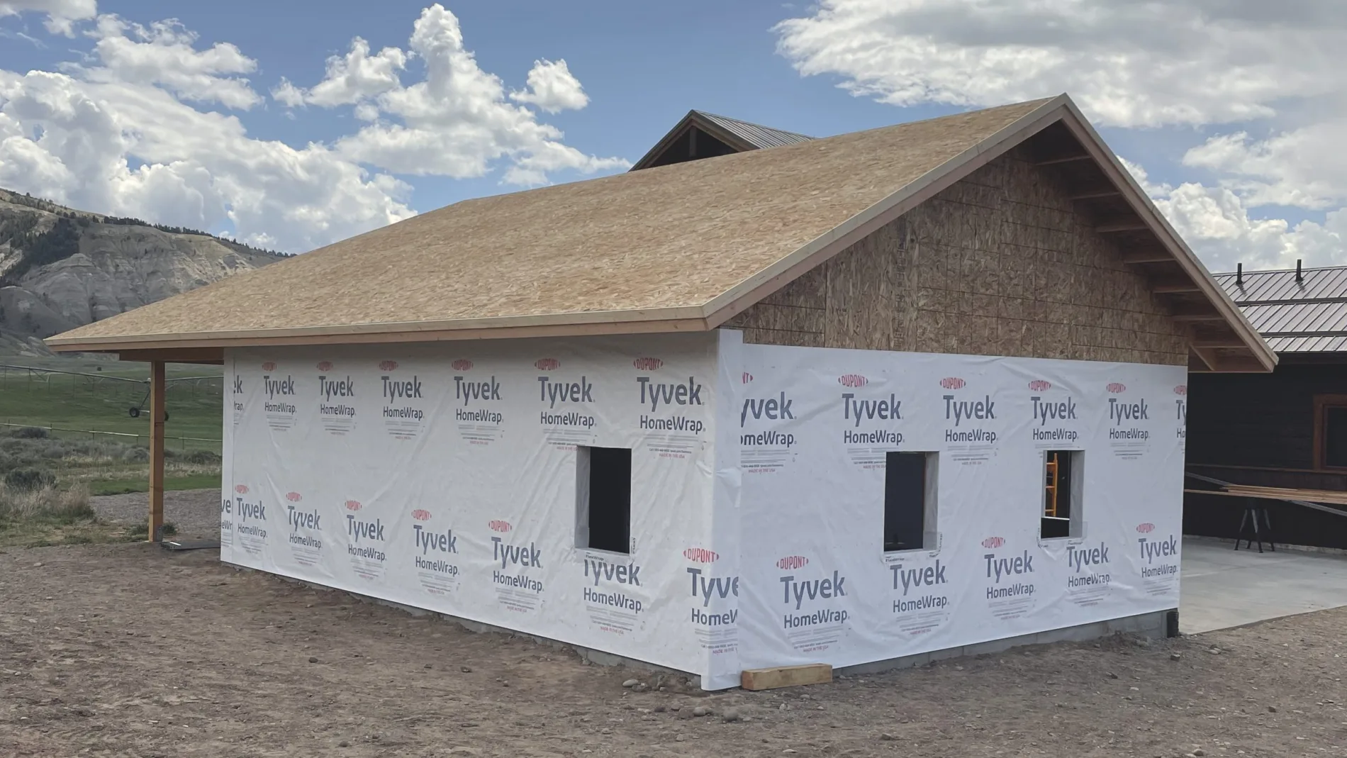 A finished building shell wrapped in house wrap, ready for siding